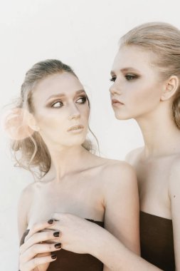 Glamour makyaj iki sokak duvar arka planda karanlık oturan uzun saç stili ile bir kadın. Moda renk portre, düzeltisiz fotoğraf