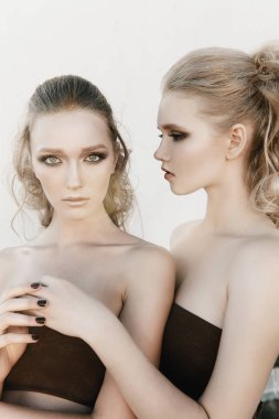 Glamour makyaj iki sokak duvar arka planda karanlık oturan uzun saç stili ile bir kadın. Moda renk portre, düzeltisiz fotoğraf