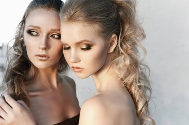 Glamour makyaj iki sokak duvar arka planda karanlık oturan uzun saç stili ile bir kadın. Moda renk portre, düzeltisiz fotoğraf
