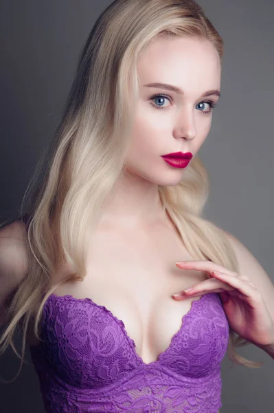 Schoonheid model meisje met perfecte make-up rode lippen en blauwe ogen kijken camera, magenta beha dragen. Portret van aantrekkelijke sexy jonge vrouw met blond haar. Mooie vrouwelijke gezicht met duidelijk vers sk — Stockfoto