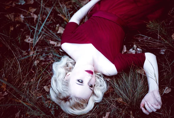 Moda linda jovem loira em belo vestido vermelho em uma floresta de conto de fadas. atmosfera mágica. Tonificação retocada tiro — Fotografia de Stock