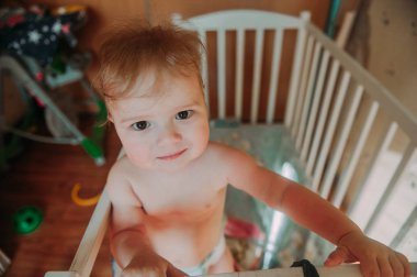 Bebek Çocuk yatağına oturmuş gülümseyerek uyandım