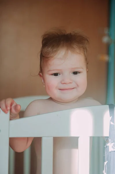 Baby boy smiling sitting in the crib just woke up — Stock Photo, Image
