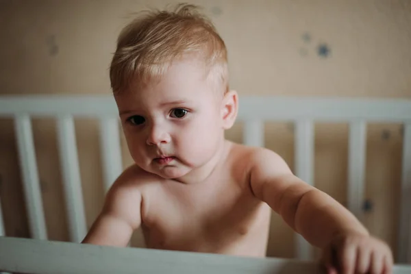 Baby boy smiling sitting in the crib just woke up — Stock Photo, Image
