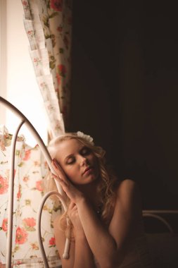 Genç güzel sarışın sabah zaman pencere yakınındaki yatakta BM