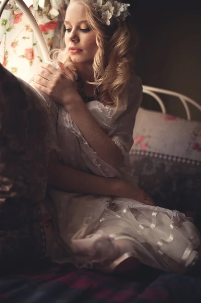 Ung smuk blondine i sengen om morgenen nær vinduet un - Stock-foto