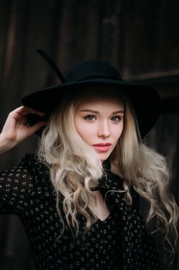 Şehirde poz siyah şapka ayakta giyen güzel çekici ve şık bir kız. Çıplak makyaj, en iyi günlük saç modeli ve büyük moda glamour ülke stil. Düzeltisiz fotoğraf