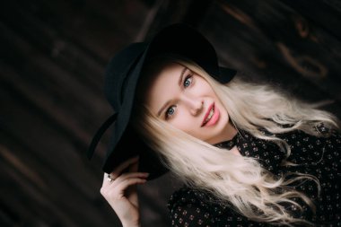 Şehirde poz siyah şapka ayakta giyen güzel çekici ve şık bir kız. Çıplak makyaj, en iyi günlük saç modeli ve büyük moda glamour ülke stil. Düzeltisiz fotoğraf