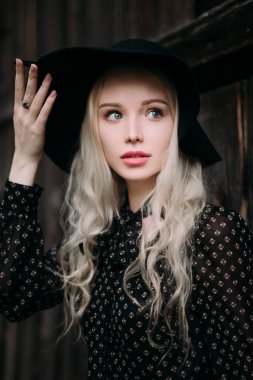 Şehirde poz siyah şapka ayakta giyen güzel çekici ve şık bir kız. Çıplak makyaj, en iyi günlük saç modeli ve büyük moda glamour ülke stil. Düzeltisiz fotoğraf