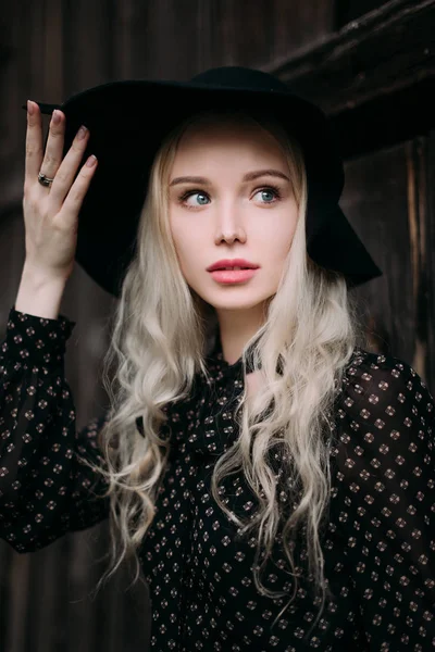 Şehirde poz siyah şapka ayakta giyen güzel çekici ve şık bir kız. Çıplak makyaj, en iyi günlük saç modeli ve büyük moda glamour ülke stil. Düzeltisiz fotoğraf