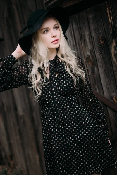Şehirde poz siyah şapka ayakta giyen güzel çekici ve şık bir kız. Çıplak makyaj, en iyi günlük saç modeli ve büyük moda glamour ülke stil. Düzeltisiz fotoğraf