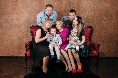 Üç nesil aile birlikte kanepede oturuyor. Klasik portre