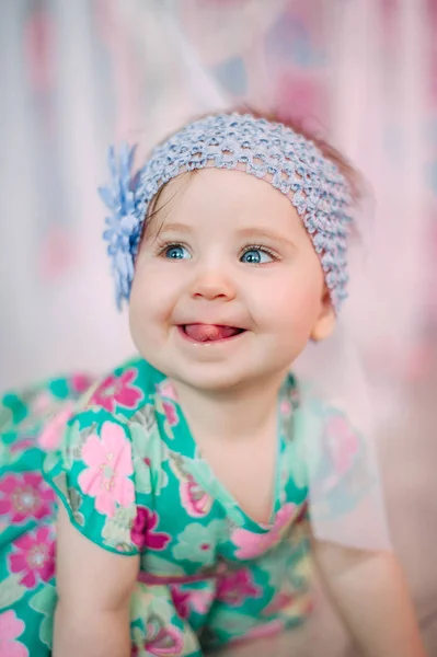 Adorable niña riéndose, sonriendo, arrastrándose y jugando en el estudio con vestido de menta — Foto de Stock
