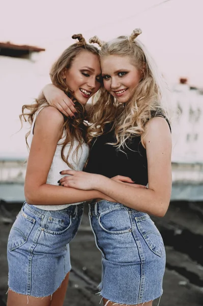 Életmód és az emberek fogalma: két stílusos lány legjobb barátja viselt farmer szoknya, kint a tetőn divat-portré. Boldog nyári idő szórakoztató. — Stock Fotó