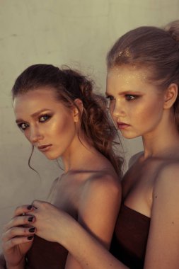 Glamour makyaj iki sokak duvar arka planda karanlık oturan uzun saç stili ile bir kadın. Moda renk portre