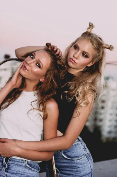 Style de vie et concept de personnes : Portrait de mode de deux filles élégantes meilleurs amis portant des jupes en jeans, à l'extérieur sur le toit. Bonne heure d'été pour s'amuser . — Photo