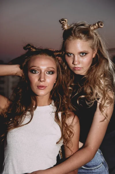 Estilo de vida y el concepto de la gente: Retrato de moda de dos chicas con estilo mejores amigos con faldas vaqueros, al aire libre en el techo. Feliz verano por diversión . — Foto de Stock