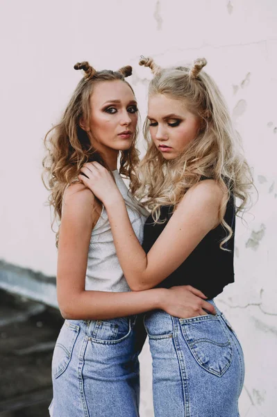 Lifestyle and people concept: Fashion portrait of two stylish girls best friends wearing jeans skirts, outdoors on the roof. Happy summer time for fun. — Stock Photo, Image