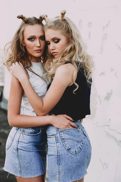 Levensstijl en mensen concept: Fashion Portret van twee stijlvolle meisjes beste vrienden dragen jeans rokken, buiten op het dak. Gelukkig zomertijd voor de lol. — Stockfoto