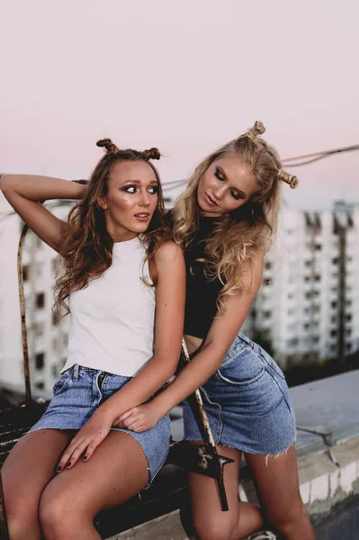 Стиль життя і концепція людей: Модний портрет двох стильних дівчат найкращих друзів у джинсових спідницях, на відкритому повітрі на даху. Щасливий літній час для розваги . — стокове фото
