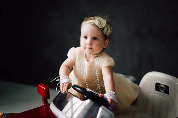 Twee baby's bruiloft - meisje verkleed als bruid spelen met speelgoedauto — Stockfoto