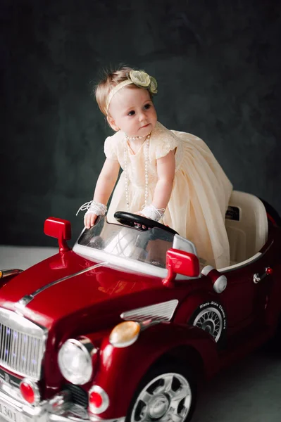 Two babies wedding - girl dressed as bride playing with toy car — Stock Photo, Image
