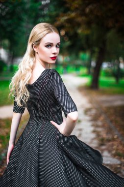 Kırmızı ruj büyük parlak gözleri olan, genç güzel sarışın kız ve sokaklarda ayar güneş trendy kıyafetler poz elbise yapmak