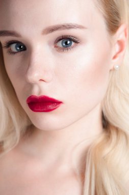 Güzellik modeli kız mükemmel makyaj ile kırmızı dudaklar ve mavi gözleri kameraya bakıyor. Sarışın çekici genç kadın portresi. Güzel kadın yüzü ile taze cilt temizleyin. Moda yakın atış.