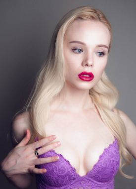 Güzellik modeli kız mükemmel makyaj ile kırmızı dudaklar ve mavi gözleri kırmızı sutyen giyiyor kameraya bakıyor. Sarışın çekici seksi genç kadın portresi. Güzel kadın yüzü ile temizleyin taze sk