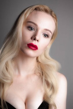 Güzellik modeli kız mükemmel makyaj ile kırmızı dudaklar ve mavi gözleri siyah sütyen giyiyor kameraya bakıyor. Sarışın çekici seksi genç kadın portresi. Güzel kadın yüzü ile temizleyin taze cilt