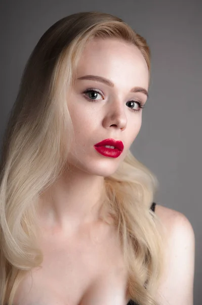 Schoonheid model meisje met perfecte make-up rode lippen en blauwe ogen kijken van de camera. Portret van aantrekkelijke jonge vrouw met blond haar. Mooie vrouwelijke gezicht met duidelijk frisse huid. Mode close-up shot. — Stockfoto