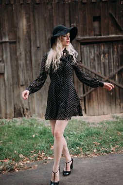 Şehirde poz siyah şapka ayakta giyen güzel çekici ve şık bir kız. Çıplak makyaj, en iyi günlük saç modeli ve büyük moda glamour ülke stil.