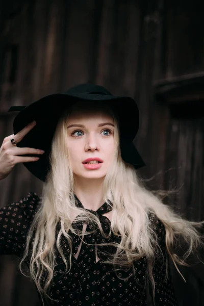 Hermosa chica atractiva y elegante con sombrero negro de pie posando en la ciudad. Maquillaje desnudo, el mejor peinado diario y gran estilo de país glamour moda . —  Fotos de Stock