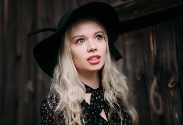 Hermosa chica atractiva y elegante con sombrero negro de pie posando en la ciudad. Maquillaje desnudo, el mejor peinado diario y gran estilo de país glamour moda . — Foto de Stock