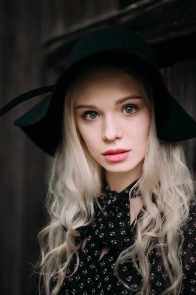 Piękny atrakcyjne i stylowe dziewczyna ubrana w czarny kapelusz stojący pozowanie w mieście. Nagie makijaż, Najlepsze fryzury dzienne i mody glamour wiejskim stylu. — Zdjęcie stockowe
