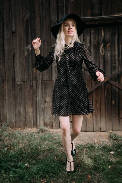 Bella ragazza attraente ed elegante indossando cappello nero in piedi in città. Trucco nudo, migliore acconciatura quotidiana e grande stile di moda glamour country . — Foto Stock