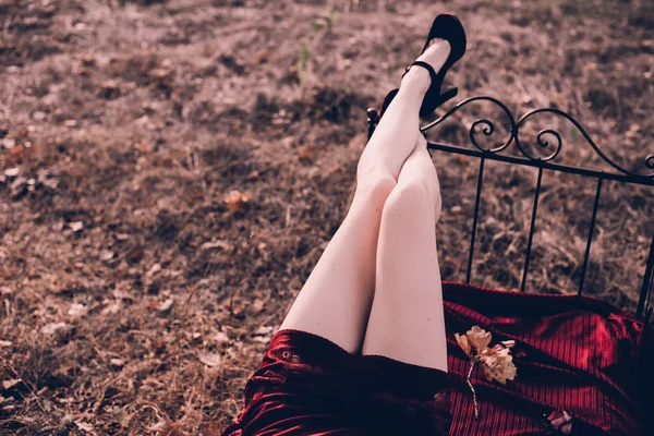 Krásná a elegantní blondýna žena nohy pózuje na posteli venku podzim, retro vintage styl a móda. — Stock fotografie