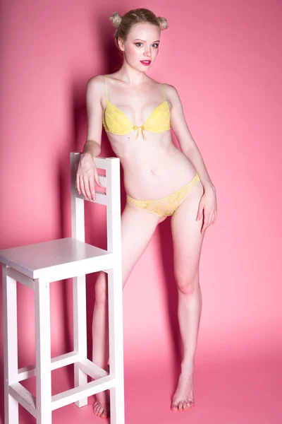 Joven sexy sonriente mujer rubia en lencería posando sobre fondo rosa, divirtiéndose, usando máscara para dormir . — Foto de Stock