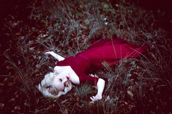 Модная красивая молодая блондинка в красивом красном платье в сказочном лесу. волшебная атмосфера. тонизирующий выстрел — стоковое фото