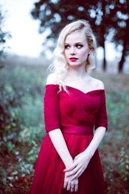 Moda güzel sarışın genç kadın bir masal ormandaki güzel Kırmızı elbiseli. sihirli bir atmosfer. atış tonlama