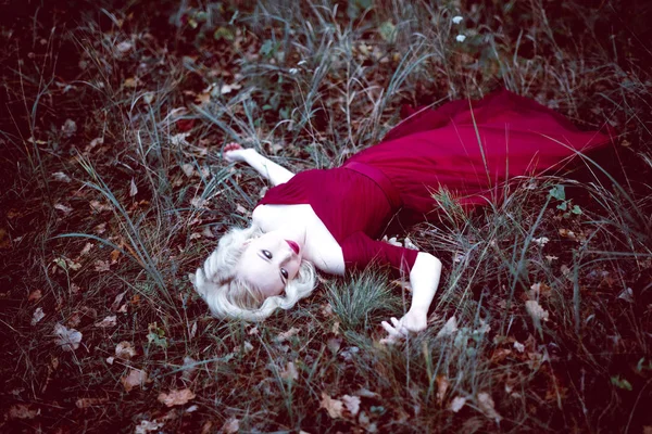 Moda linda jovem loira em belo vestido vermelho em uma floresta de conto de fadas. atmosfera mágica. tonificação tiro — Fotografia de Stock