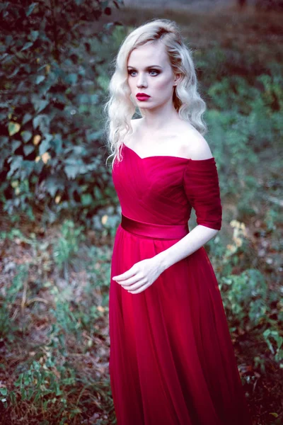 Μόδα πανέμορφη νεαρή ξανθιά γυναίκα στο όμορφο κόκκινο φόρεμα σε ένα παραμυθένιο δάσος. μαγική ατμόσφαιρα. τόνωση βολή — Φωτογραφία Αρχείου