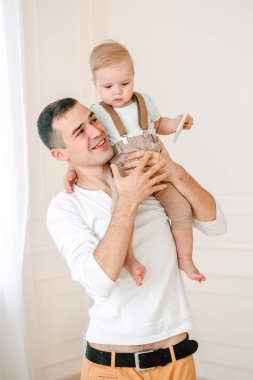 Yakışıklı baba ve oğul 1 yıl mutlu ve gülümseyen gün anda stüdyoda sarılma eğleniyor eski portresi. Dostu aile kavramı.