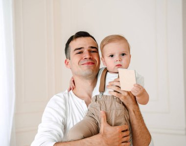 Yakışıklı baba ve oğul 1 yıl mutlu ve gülümseyen gün anda stüdyoda sarılma eğleniyor eski portresi. Dostu aile kavramı.