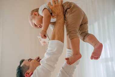 Yakışıklı baba ve oğul 1 yıl mutlu ve gülümseyen gün anda stüdyoda sarılma eğleniyor eski portresi. Dostu aile kavramı.