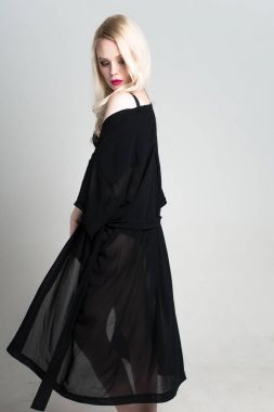 genç seksi gülümseyen sarışın kadın siyah iç çamaşırı beyaz arka plan üzerinde poz.