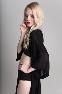 genç seksi gülümseyen sarışın kadın siyah iç çamaşırı beyaz arka plan üzerinde poz.