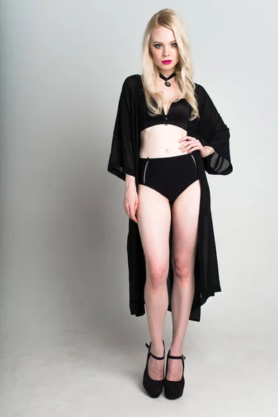 Jovem sexy sorrindo mulher loira em lingerie preta posando no fundo branco . — Fotografia de Stock