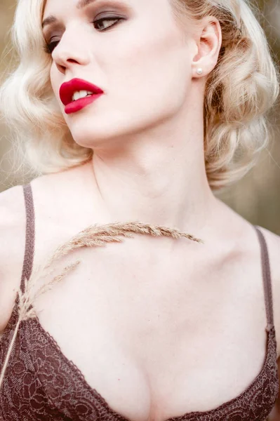 Mooi en elegant lachende sexy blonde vrouw met rode lippen en haren golven dragen beige liingerie poseren op het veld buiten zomer, retro vintage stijl en mode. Geretoucheerde kunst toning sho — Stockfoto