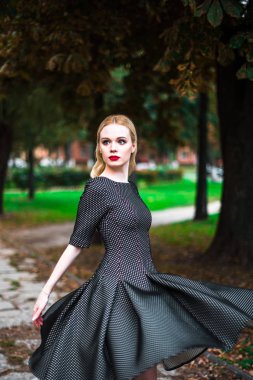 Kırmızı ruj büyük parlak gözleri olan, genç güzel sarışın kız ve sokaklarda ayar güneş trendy kıyafetler poz elbise yapmak